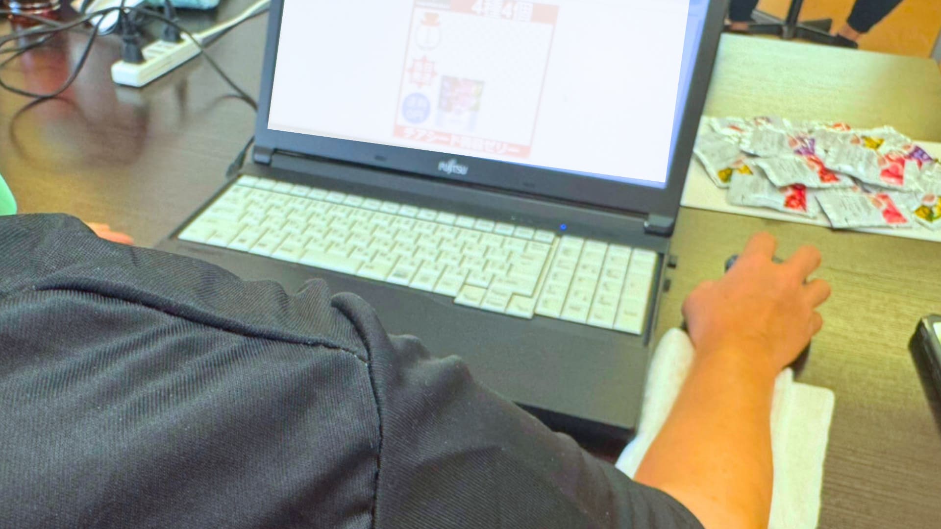 パソコンに向かって作業をしている人の後ろ姿